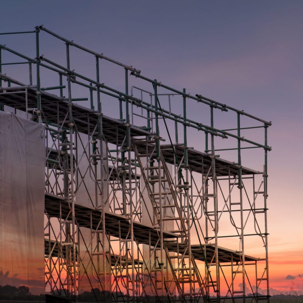 Construction,Site,With,Scaffold,Tower,And,Building,With,Sunset,Background,scaffolding